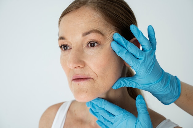 Chiudere le mani con i guanti che tengono il viso della donna