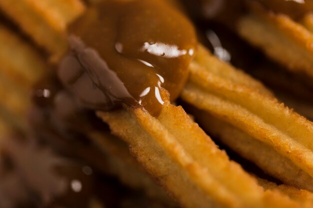 Churros estremi del primo piano con cioccolato fuso