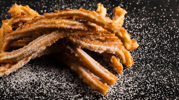 Churros fritti deliziosi con l'alta vista dello zucchero