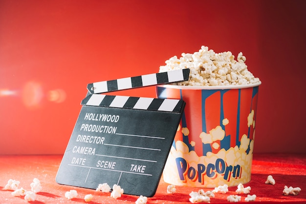 Ciak vuoto vicino grande secchio di popcorn