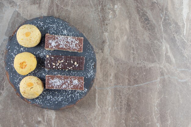 Cialda croccante al cioccolato e pasta frolla a bordo su marmo.