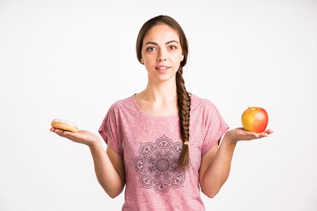 Ciambella e mela di confronto della donna