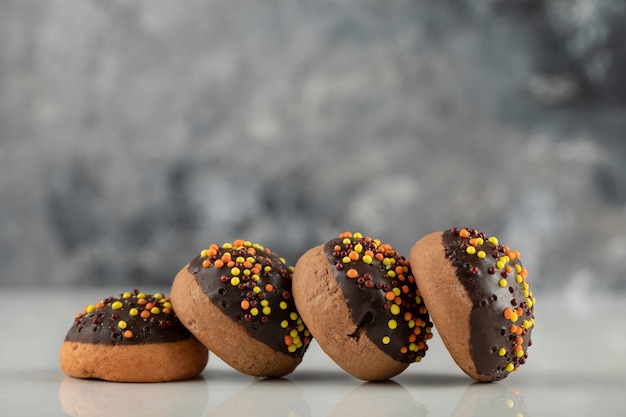 Ciambelle dolci al cioccolato con confettini colorati.