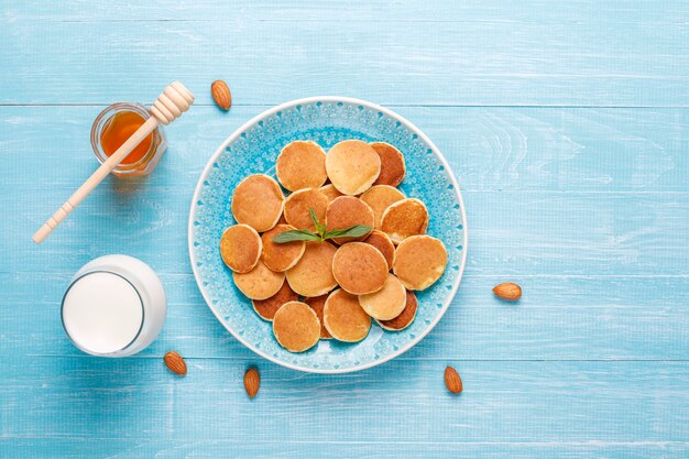 Cibo alla moda - cereali mini pancake. Mucchio di frittelle di cereali con frutti di bosco e noci.