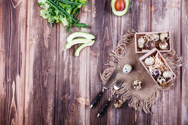 Cibo fresco e sano, proteine. Le uova di quaglia in scatola di legno stanno sul tavolo rustico