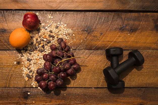 Cibo sano con manubri su fondo in legno