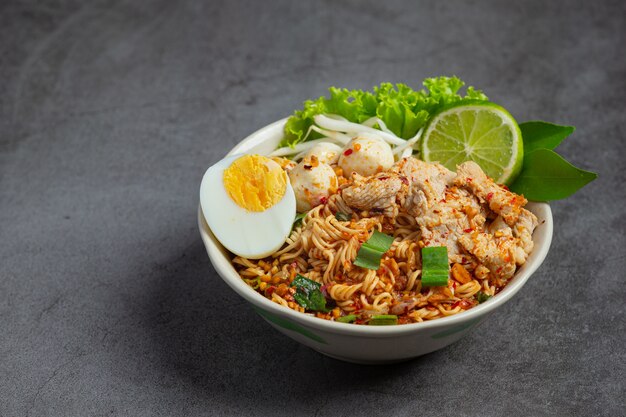 Cibo thailandese. bollire le tagliatelle piccanti con carne di maiale e bollire l'uovo