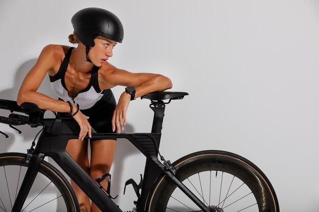 Ciclista donna in posa con casco e bicicletta