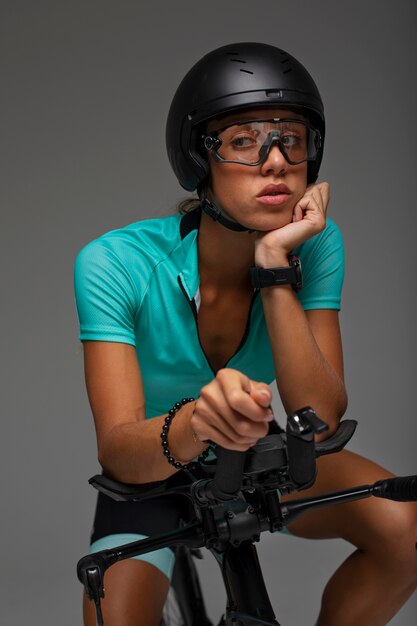 Ciclista femminile che indossa il casco e posa con la bicicletta