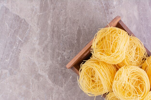 Cime di tagliatelle isolate sullo spazio grigio.