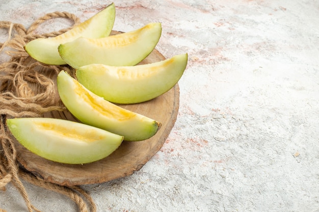 Cinque fette di melone su un piatto di legno e una corda sul lato sinistro del marmo