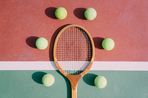 Cinque palle da tennis e racchetta in simmetria