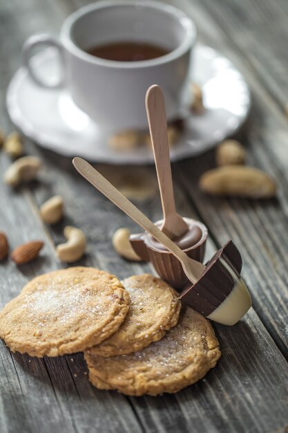 Cioccolatini, biscotti e noci sulla superficie in legno