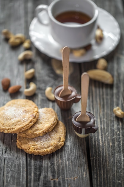 Cioccolatini, biscotti e noci sulla superficie in legno