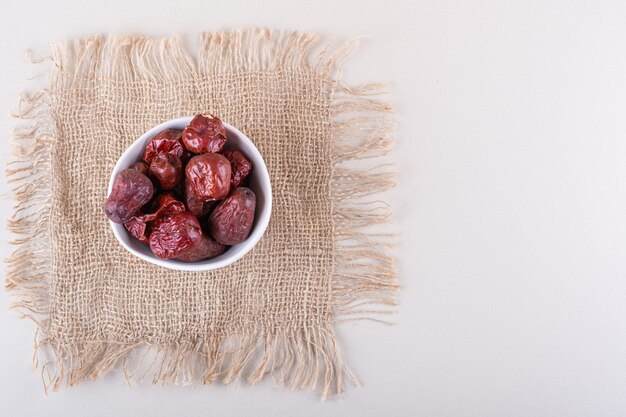 Ciotola bianca di frutti secchi di silverberry gustosi su sfondo bianco. Foto di alta qualità