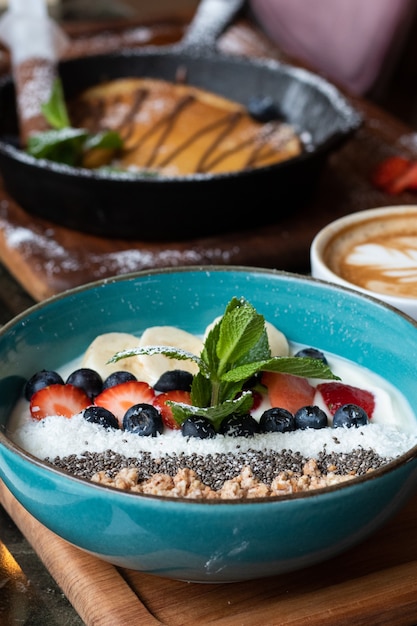 Ciotola blu con cereali e vari frutti deliziosi