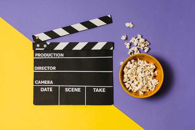 Ciotola con popcorn accanto all'ardesia di film