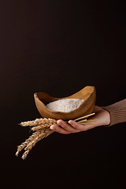 Ciotola della holding della mano ad alto angolo con riso e cereali