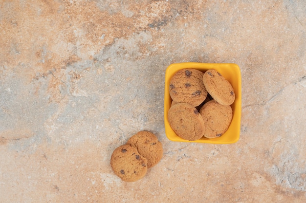 Ciotola di biscotti al cioccolato su sfondo marmo.