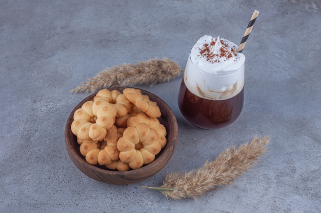 Ciotola di biscotti dolci con un bicchiere di caffè sulla superficie in marmo.