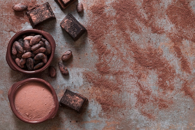 Ciotola di cacao in polvere e fagioli con pezzi di cioccolato