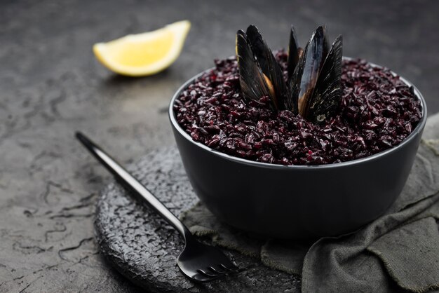 Ciotola di cozze con forcella e fetta di limone