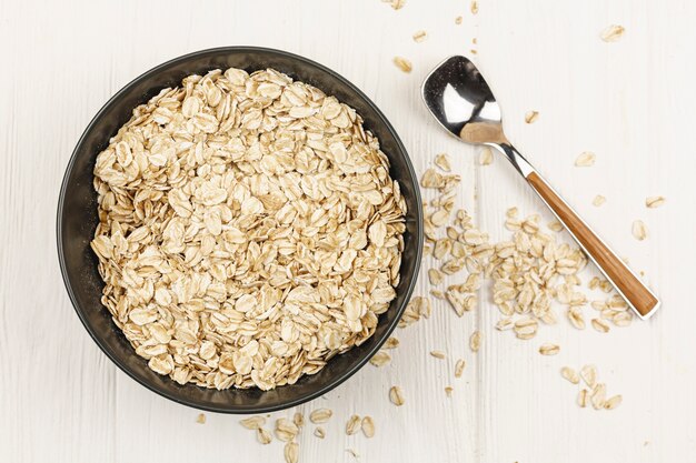 Ciotola di farina d'avena con cucchiaio sul tavolo