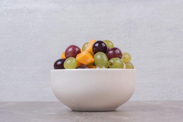 Ciotola di frutta mista sulla tavola di marmo.