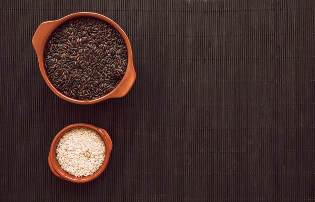 Ciotola di grano di riso in bianco e nero su placemat di legno
