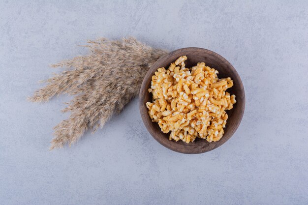 Ciotola di legno di caramelle dure con noci su pietra.