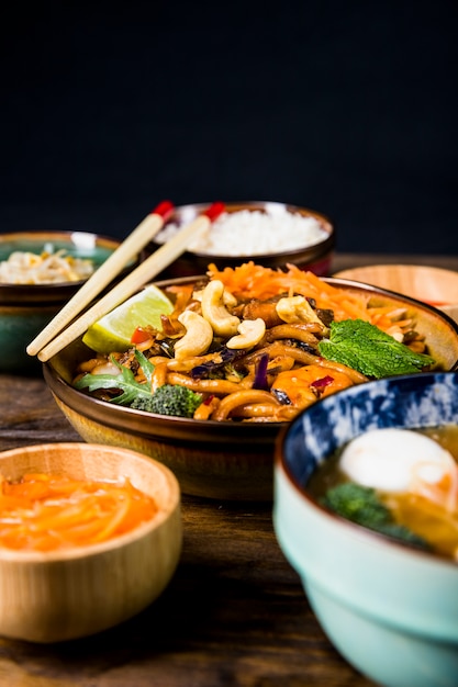 Ciotola di noodles udon thai con noci; broccoli; condimenti al limone e menta