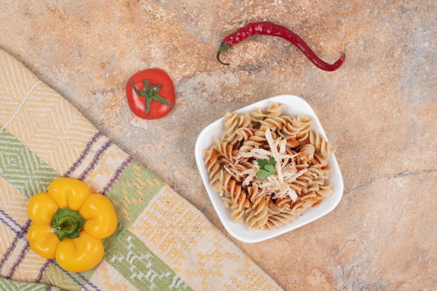 Ciotola di pasta fusilli e verdure fresche sulla tovaglia