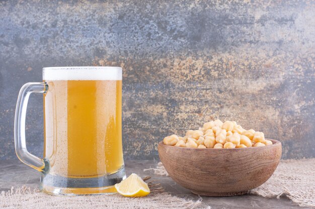 Ciotola di piselli e bicchiere di birra sul tavolo di marmo. Foto di alta qualità
