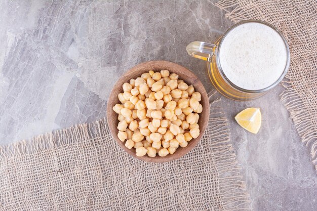 Ciotola di piselli e bicchiere di birra sulla superficie di marmo. Foto di alta qualità