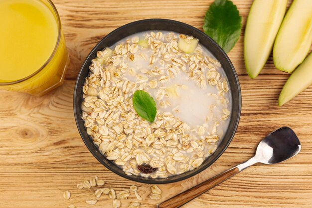 Ciotola di porridge di farina d'avena con una tazza di succo d'arancia