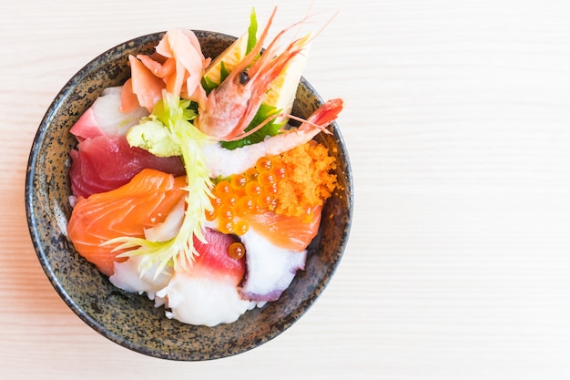 Ciotola di riso giapponese con sashimi frutti di mare in cima