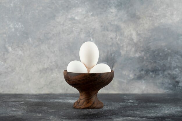 Ciotola di uova bianche sulla superficie in marmo.