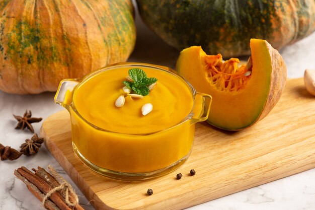 Ciotola di zuppa di zucca posto sul tagliere di legno