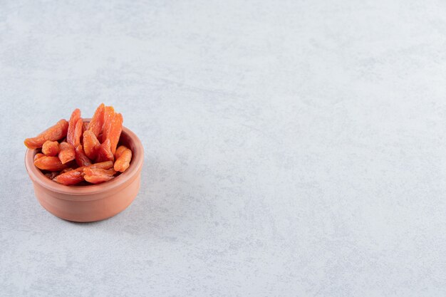 Ciotola in ceramica con deliziosa frutta secca su pietra.