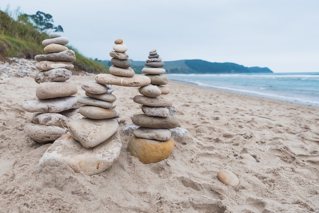 Ciottoli impilati l'uno sull'altro in equilibrio sulla spiaggia