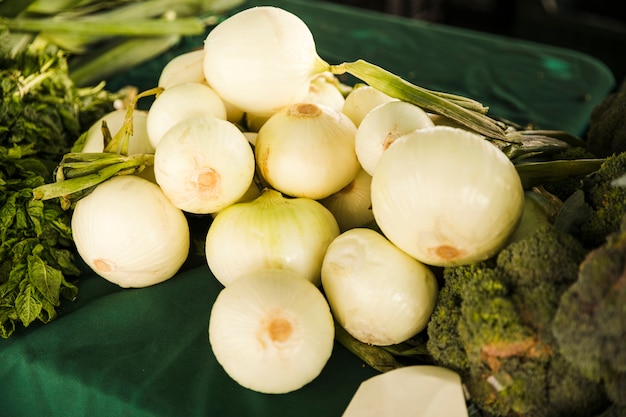 Cipolla bianca in buona salute con la verdura verde sulla tavola al mercato