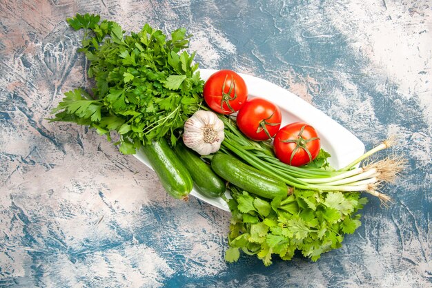 Cipolla verde fresca vista dall'alto con pomodori e verdure su sfondo azzurro