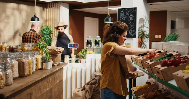 Cliente che mette le verdure nel sacchetto di carta