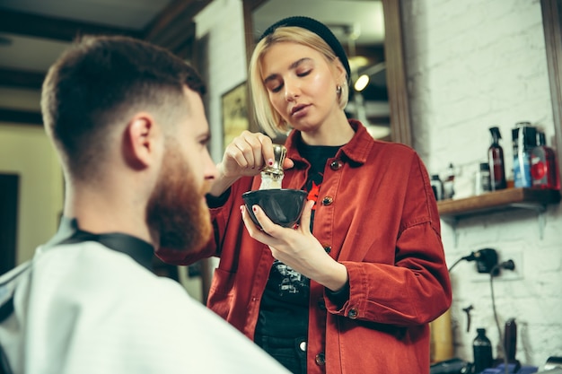 Cliente durante la rasatura della barba nel negozio di barbiere