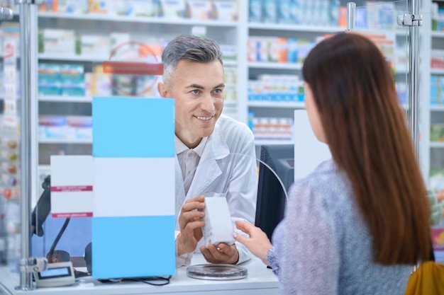 Cliente femminile in piedi vicino al bancone della farmacia