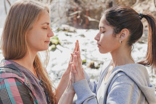 Close-up della donna con gli occhi chiusi e le mani insieme