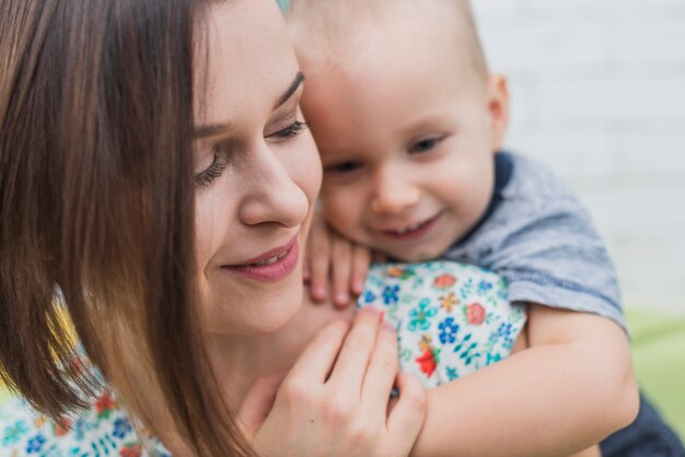 Close-up della donna felice con il suo figlio accanto alla sua spalla