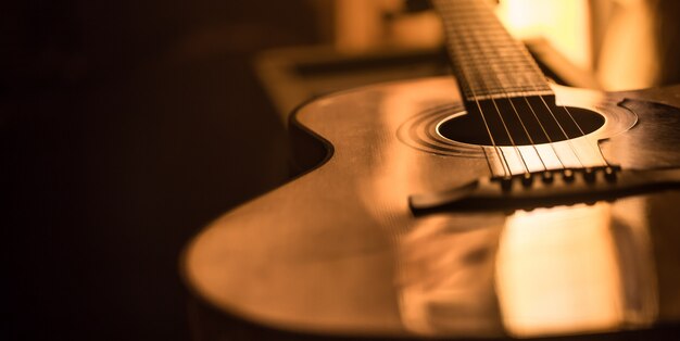 Close-up di chitarra acustica su uno sfondo colorato bello