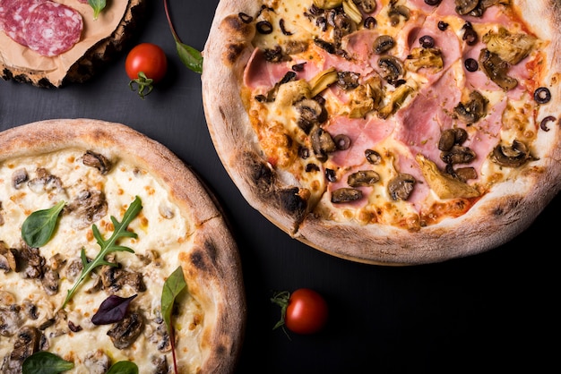 Close-up di due pizza italiana con diversi condimenti e pomodorini