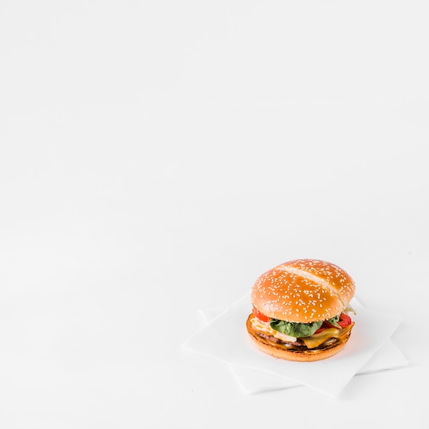 Close-up di hamburger fresco su carta velina su sfondo bianco